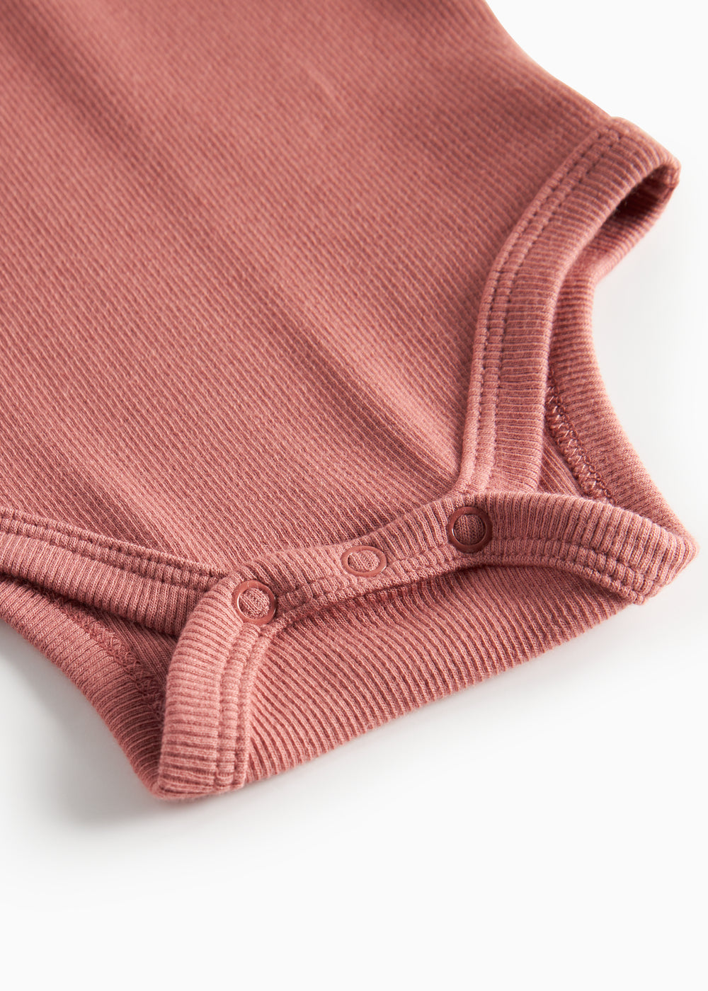 Støvet rosa ribstrikket babybody 