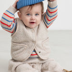 Beige teddy-vest med knapper og lommer, set på barn i løstsiddende model