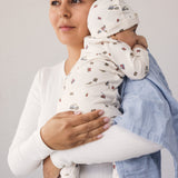 Baby holdt af kvinde med stofble over skulderen