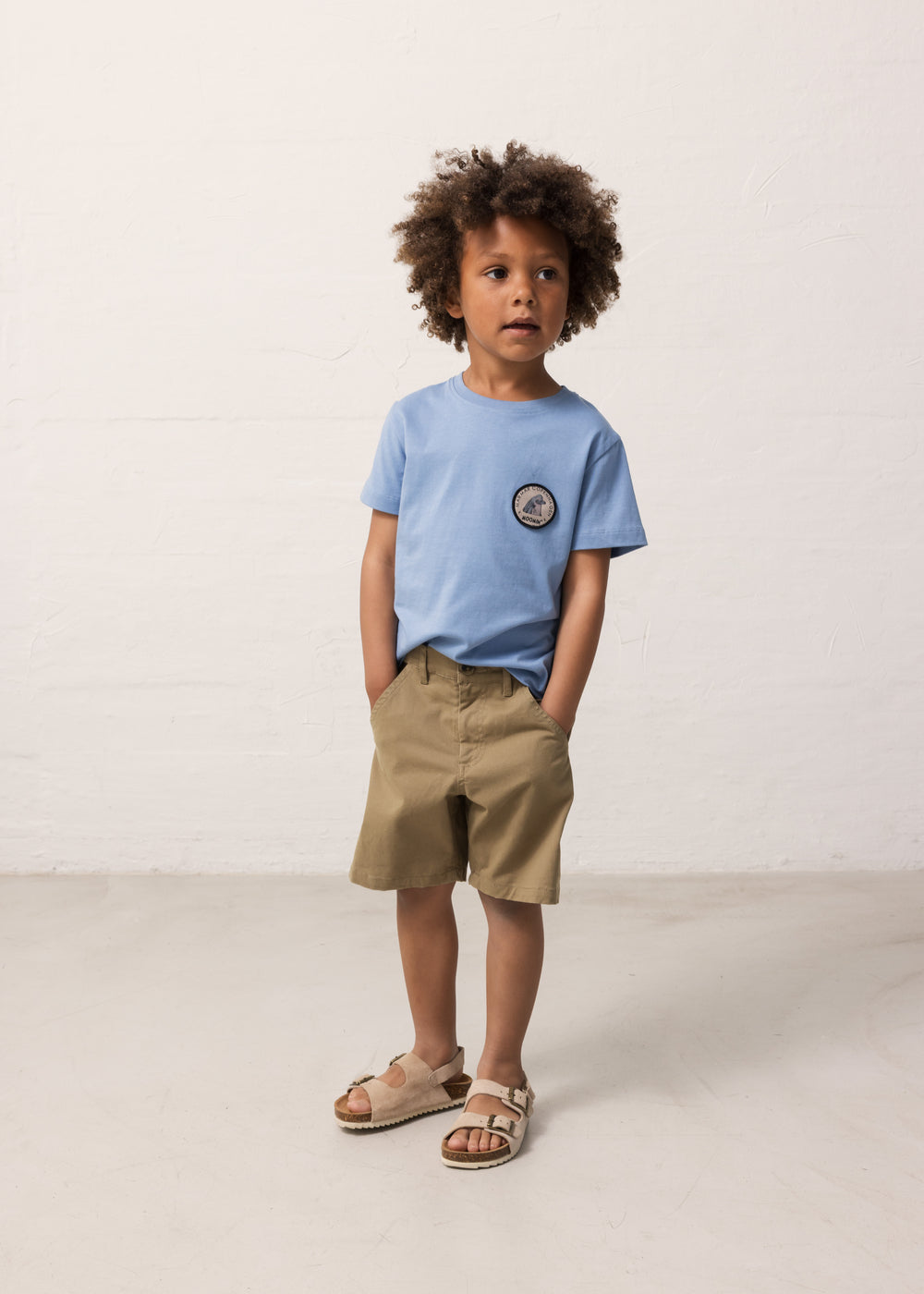 Barn iført lyseblå T-shirt og khakifarvede shorts