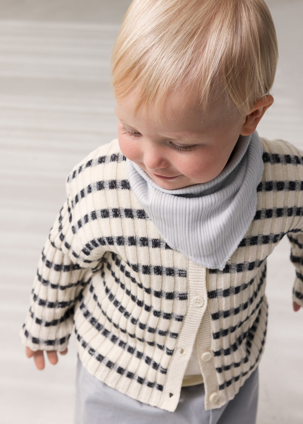 Baby iført strik cardigan med rund hals, striber og knaplukning