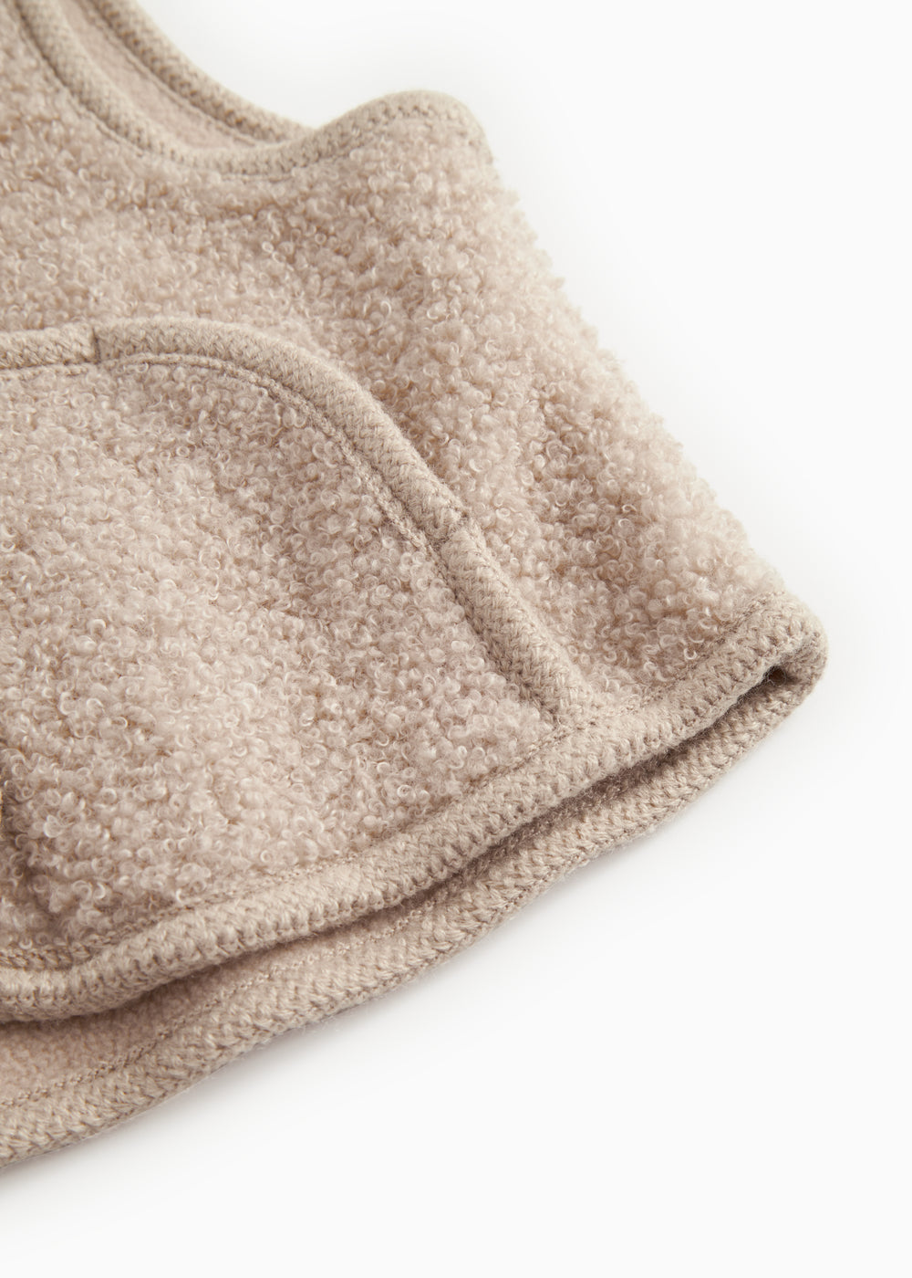 Beige teddy-vest i bouclé med ribkant ved åbning og trykknaplukning