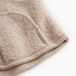 Beige teddy-vest i bouclé med ribkant ved åbning og trykknaplukning