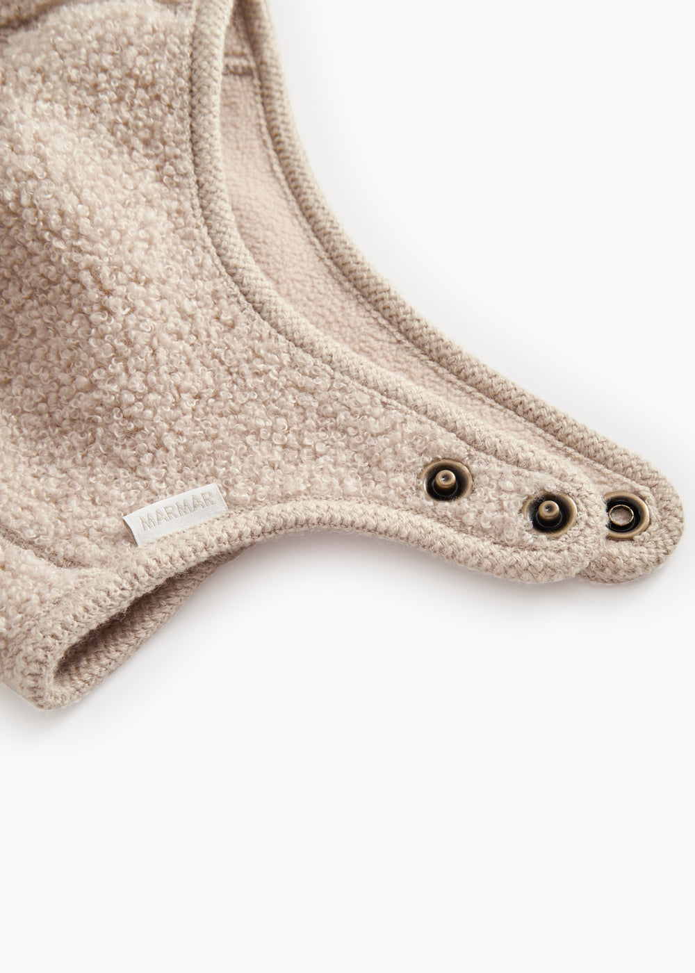 Teddyhue i mudret beige med trykknapper ved nederkant og rund krave