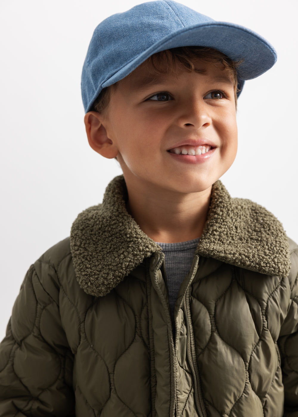 Arlo kasket i lyseblå denim med buet skygge set forfra