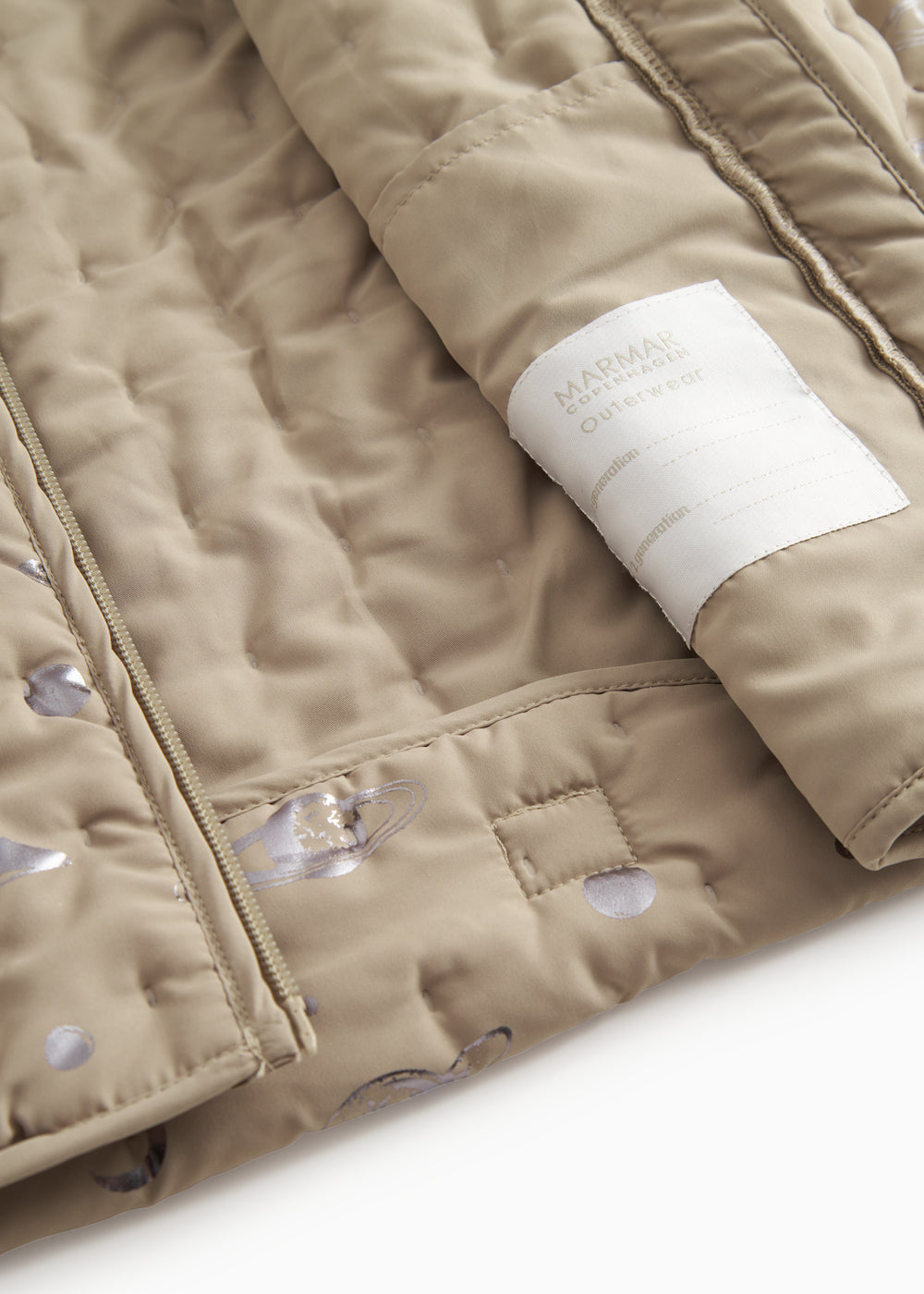 Beige quiltet termojakke med mærkeetiket på indersiden