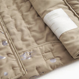 Beige quiltet termojakke med mærkeetiket på indersiden