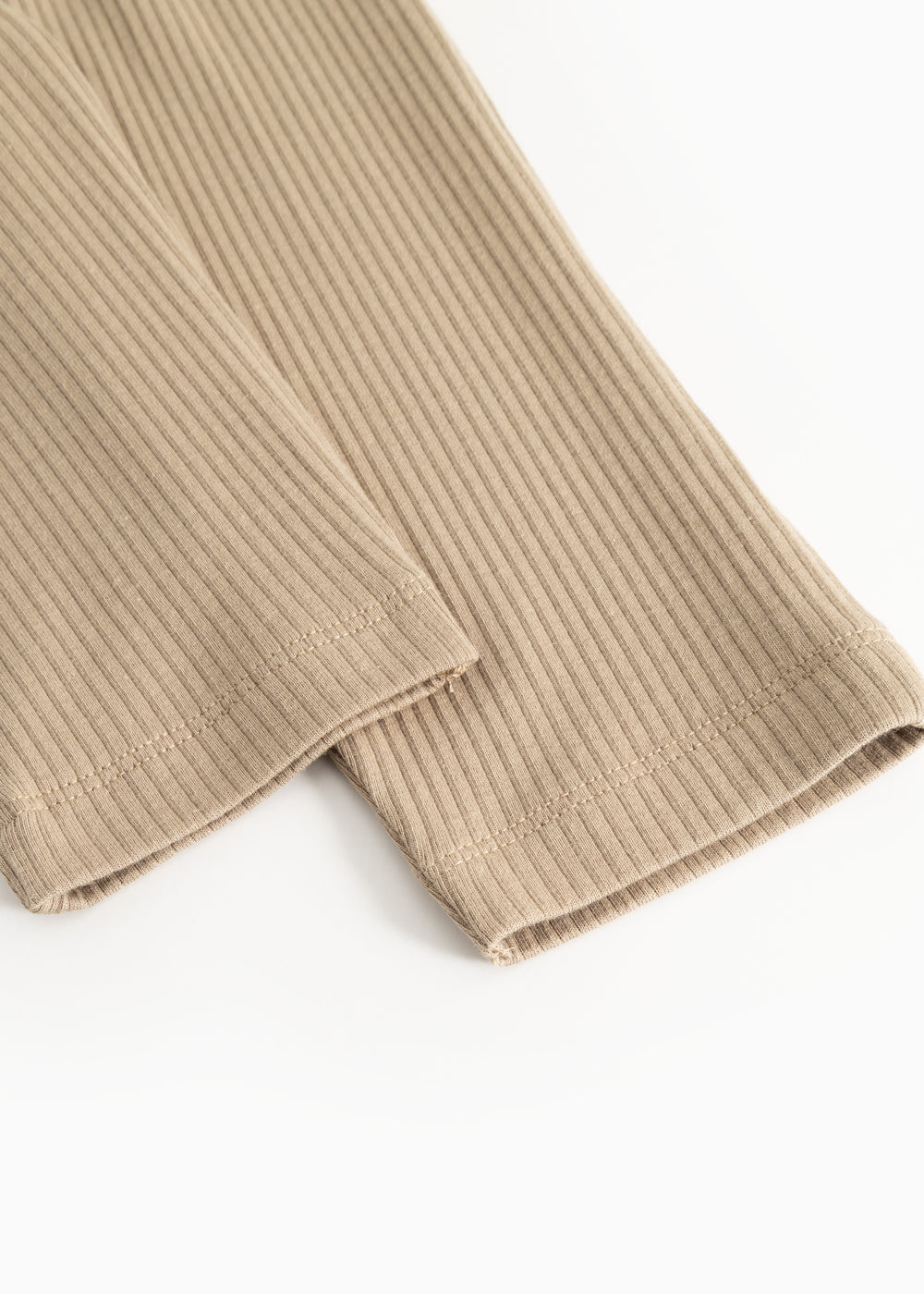 Beige ribbukser med ribbet stof og søm ved benkanten