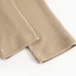Beige ribbukser med ribbet stof og søm ved benkanten