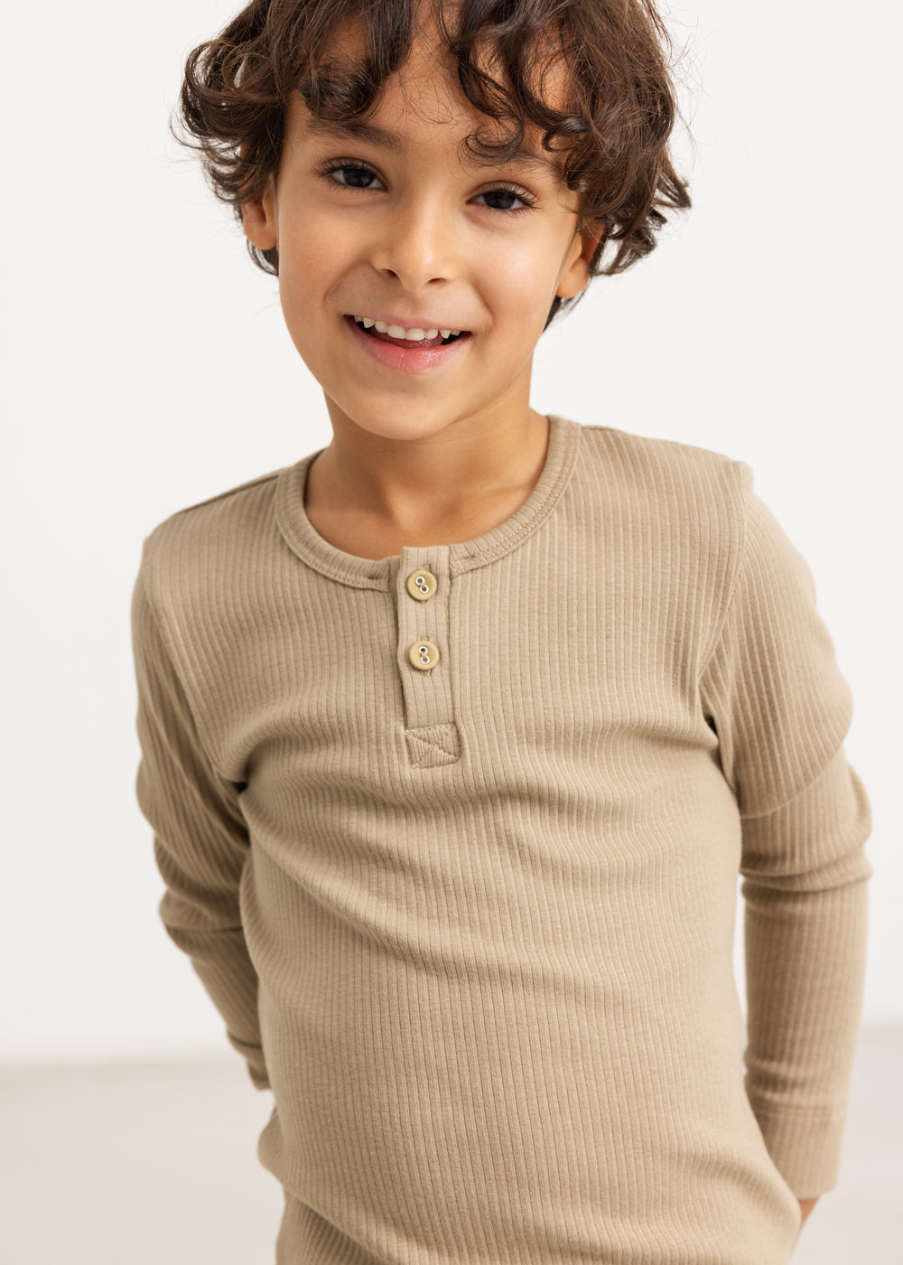 Beige langærmet t-shirt med knaplukning og rund hals på barnet