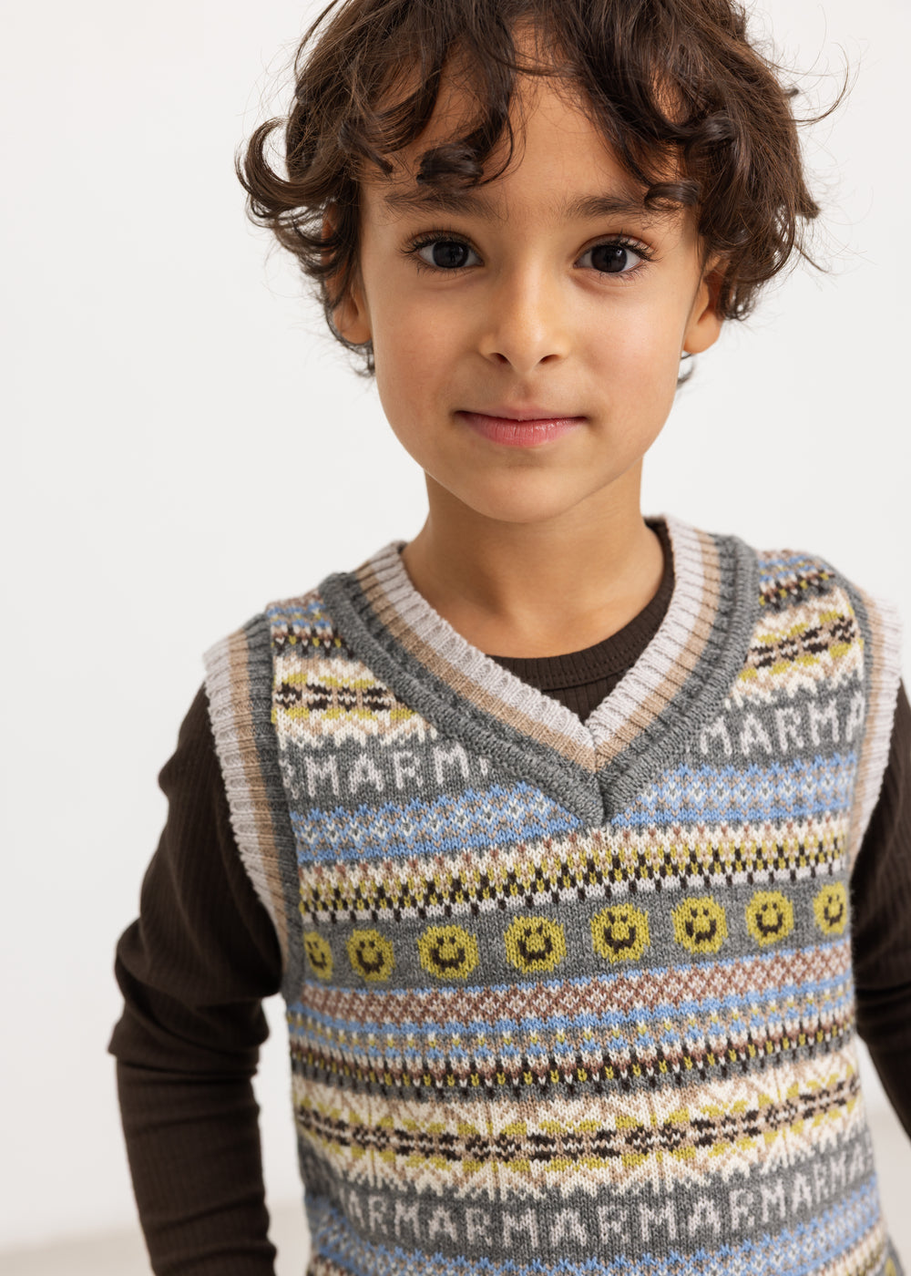 Mørkebrun langærmet T-shirt med rund hals, synlig under ternet vest