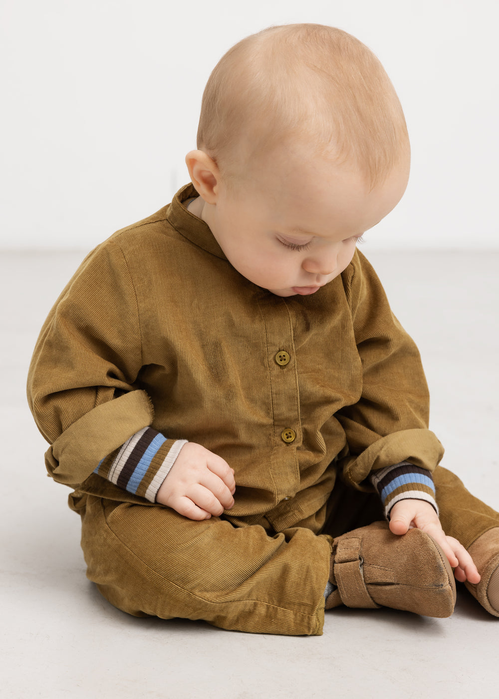Babyskjorte i mørk bronze med knaplukning, set fra siden
