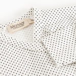 Detalje: hvid bodystocking med små sorte prikker og mærke ved hals