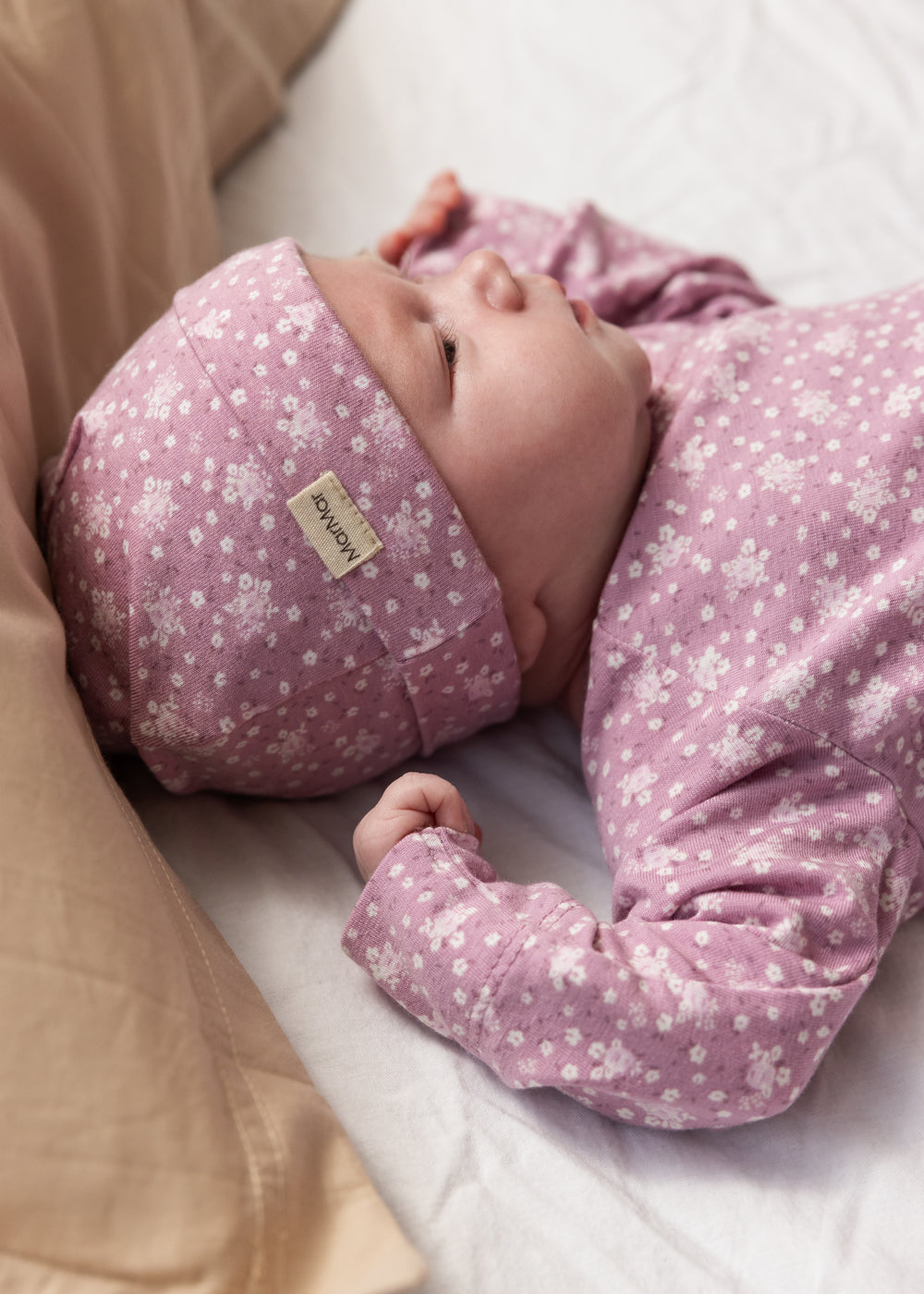 Lyserød bodystocking med små blomster og lange ærmer på baby