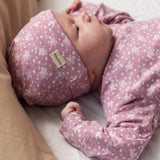 Lyserød bodystocking med små blomster og lange ærmer på baby