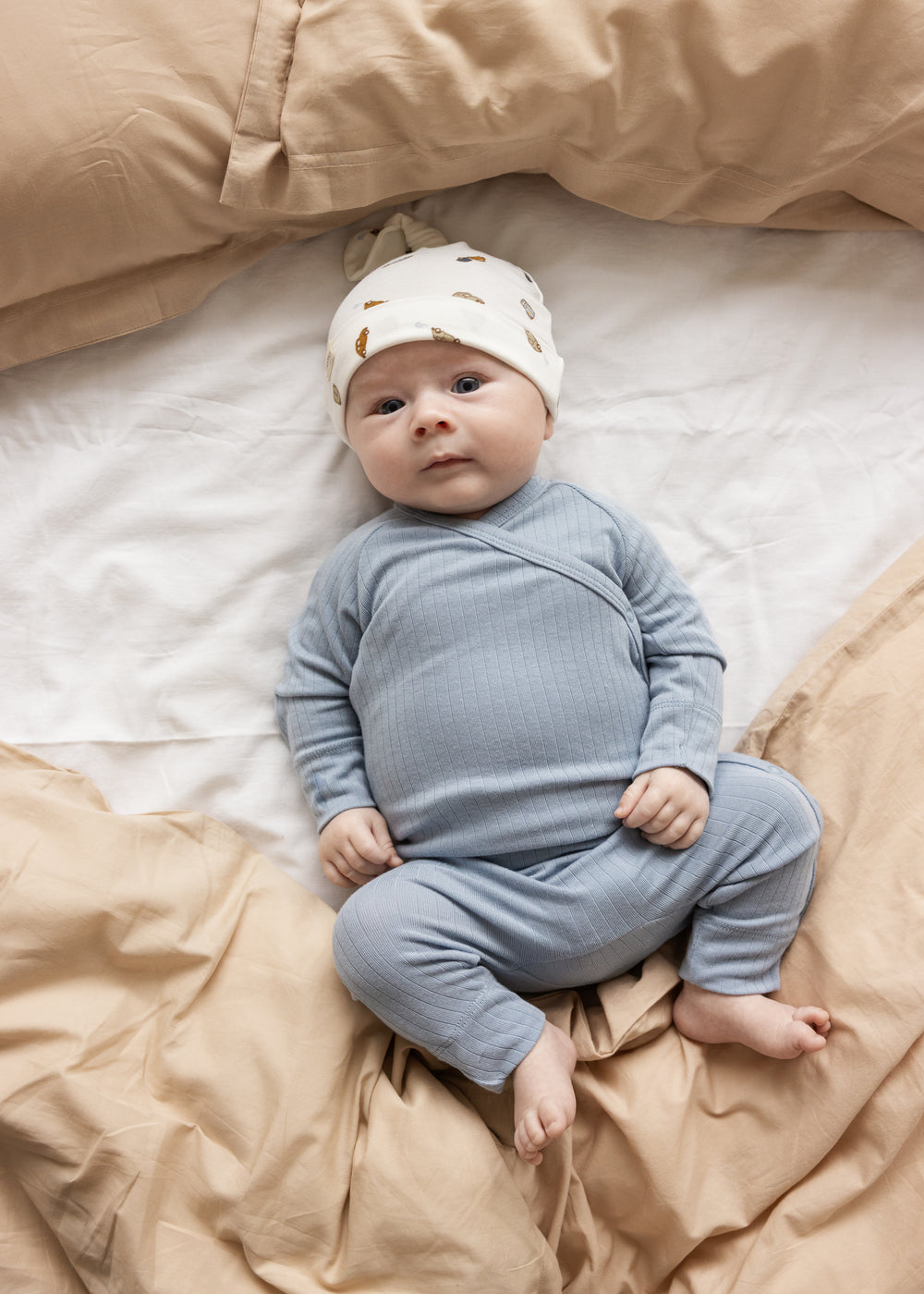Baby iført lyseblå langærmet bodystocking med ribmønster