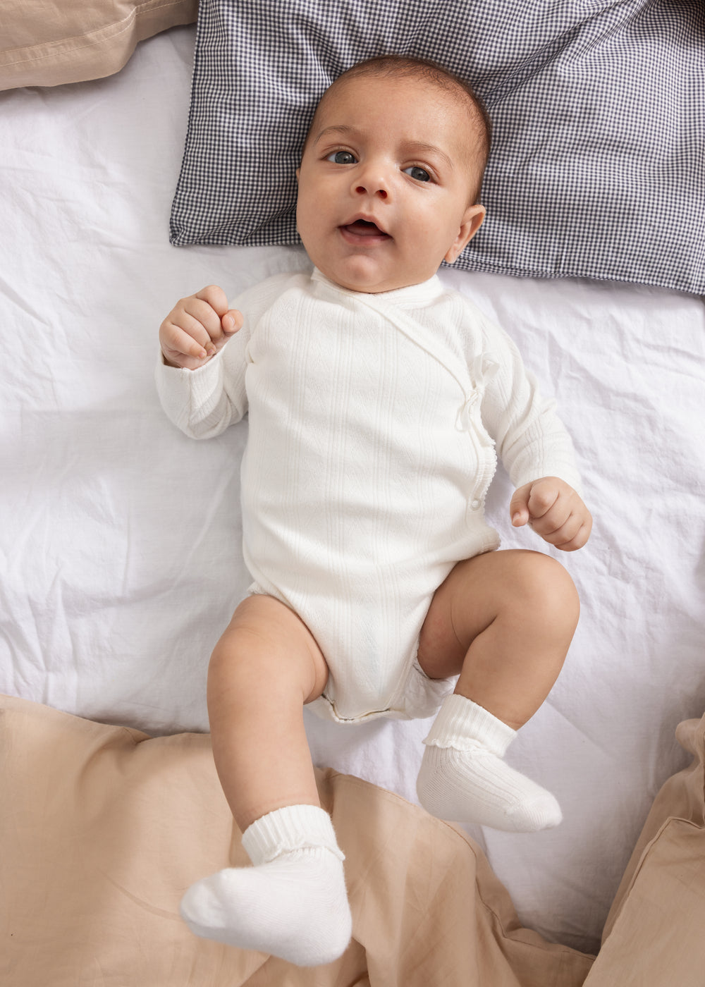 Hvid langærmet bodystocking på baby med lukkere i skridtet