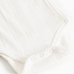 Hvid baby-bodystocking med trykknapper i skridtet og knaplukning ved halsen