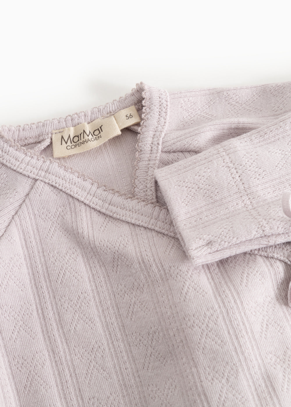 Detalje af baby-bodystocking i lys lilla med MarMar Copenhagen-mærke