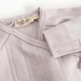 Detalje af baby-bodystocking i lys lilla med MarMar Copenhagen-mærke