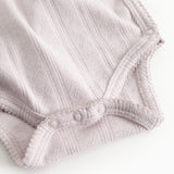 Baby-bodystocking i lys lilla med ribkant ved benåbning