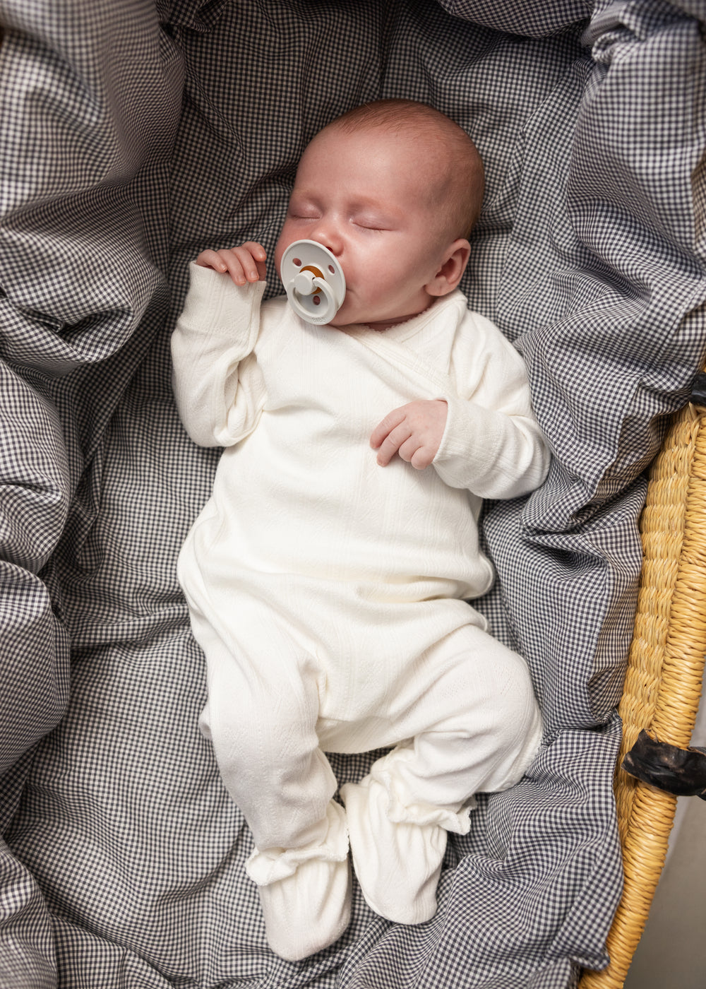 Hvid babyheldragt med sløjdedetalje ved hals på spædbarn