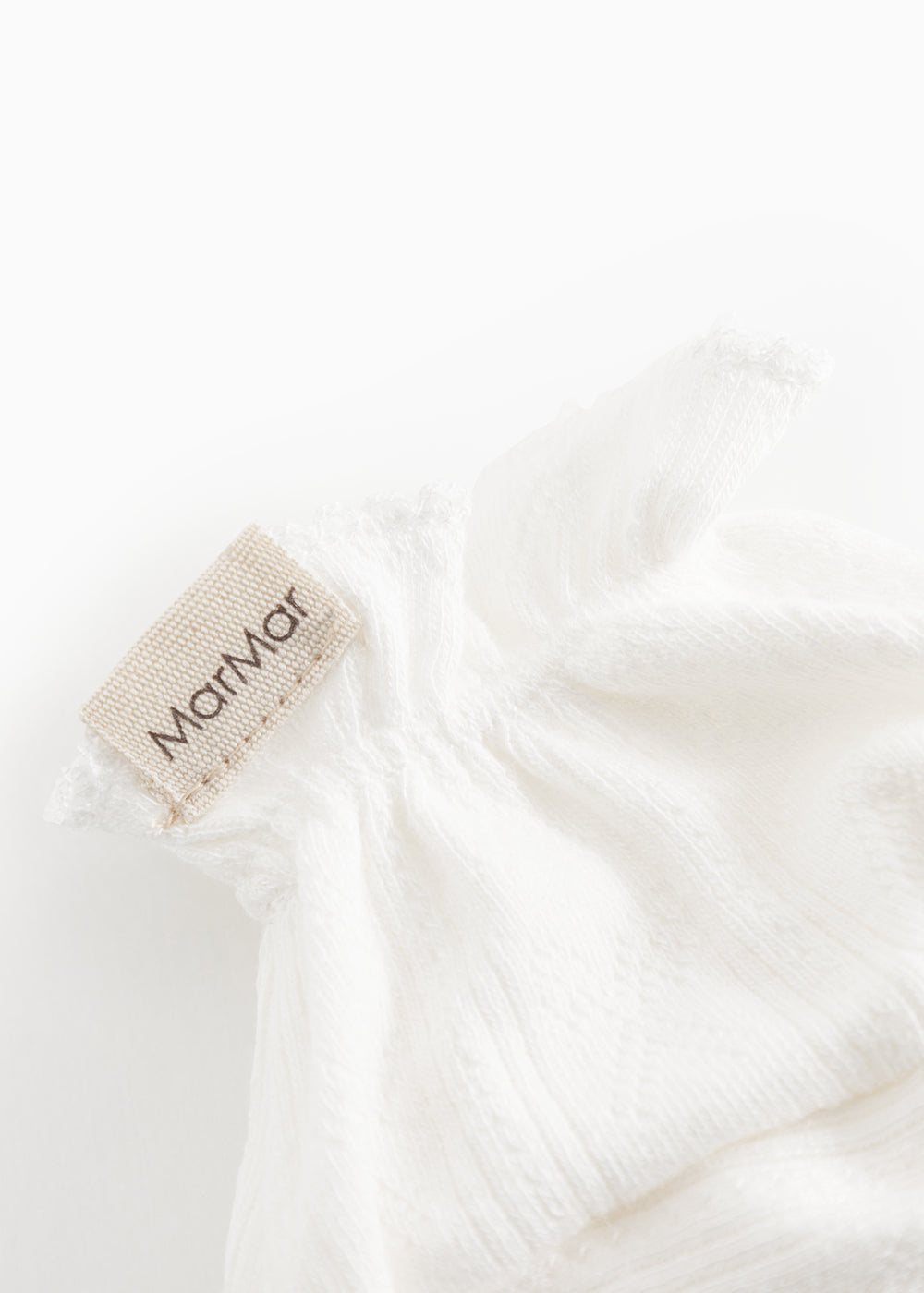 Hvide baby-booties med MarMar tekstiletikette og blød flæsekant ved åbningen