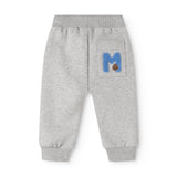 Grå babybukser med blå logo-patch og elastiske manchetter