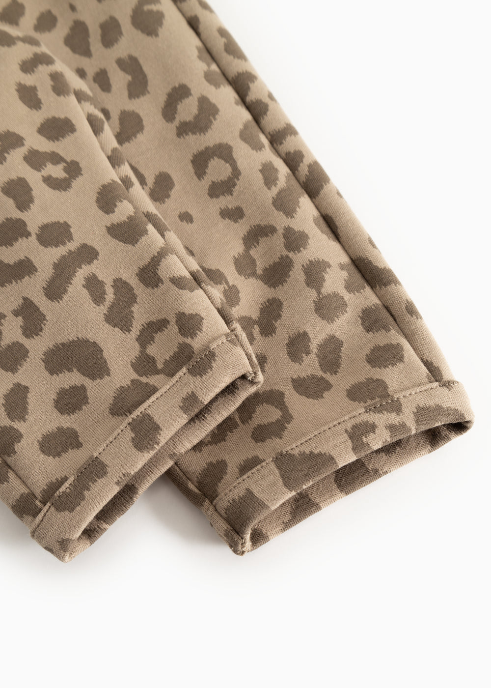 Detalje af leopardmønstret bukseben med søm og elastisk kant forneden
