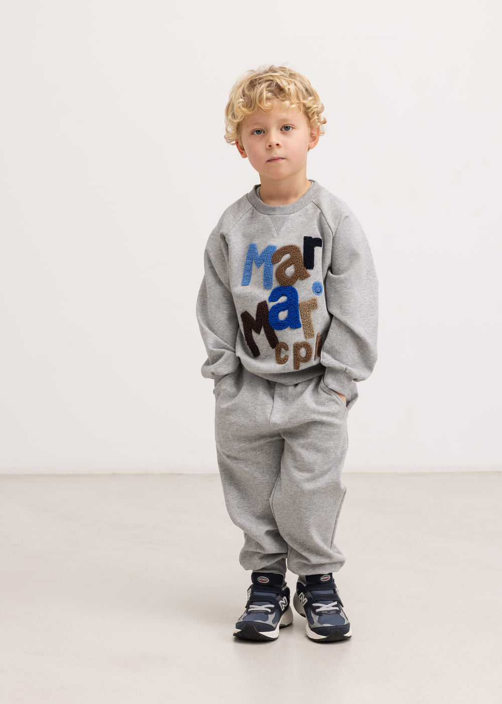 Grå sweatshirt med flerfarvet logo-print foran, rund hals og lange ærmer