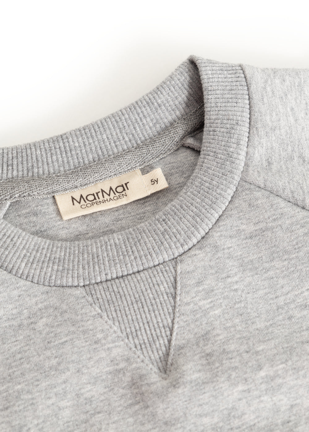 Grå sweatshirtbluse med ribkrave og indvendig mærkeetiket ved halsudskæring.