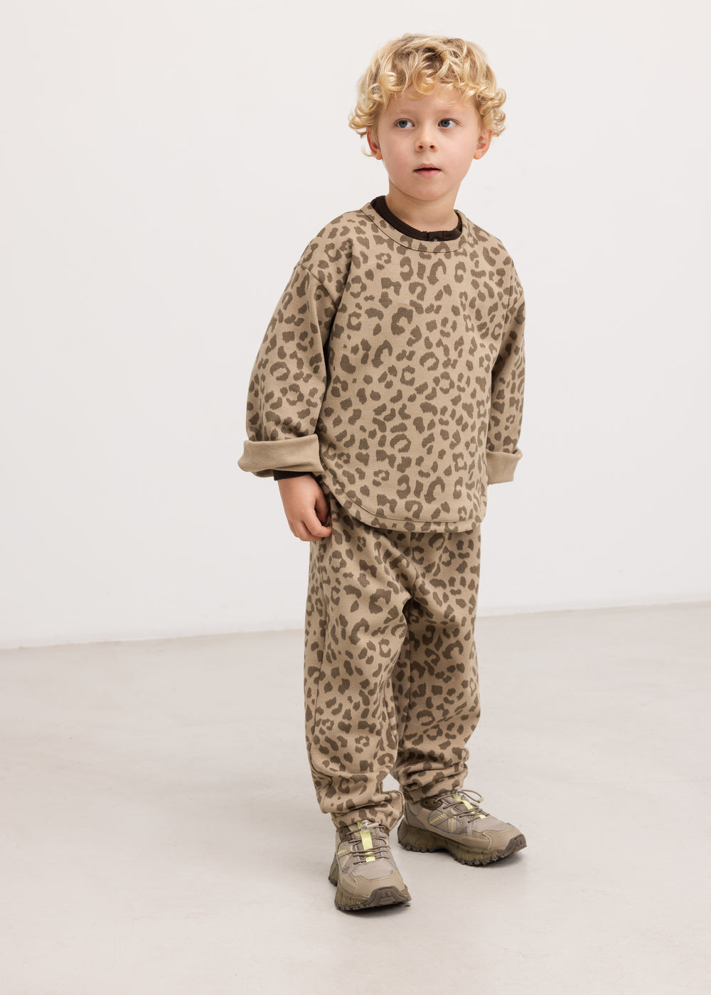 Barnbluse i beige leopardprint med rund hals og lange ærmer, båret af barn