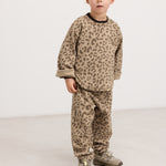 Barnbluse i beige leopardprint med rund hals og lange ærmer, båret af barn