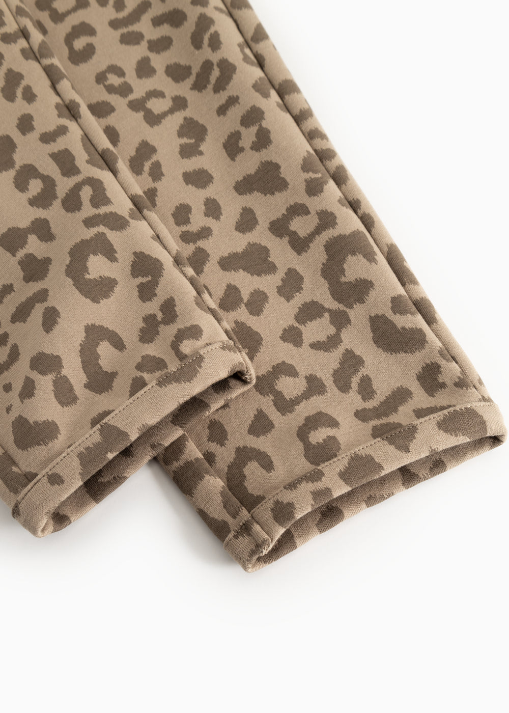 Peon bukser: tæt leopardmønster i beige stof, synlig søm ved benåbning