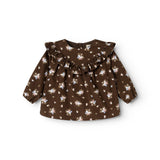 Brun babybluse med rund hals, flæsekrave og knaplukning; små blomster overalt.