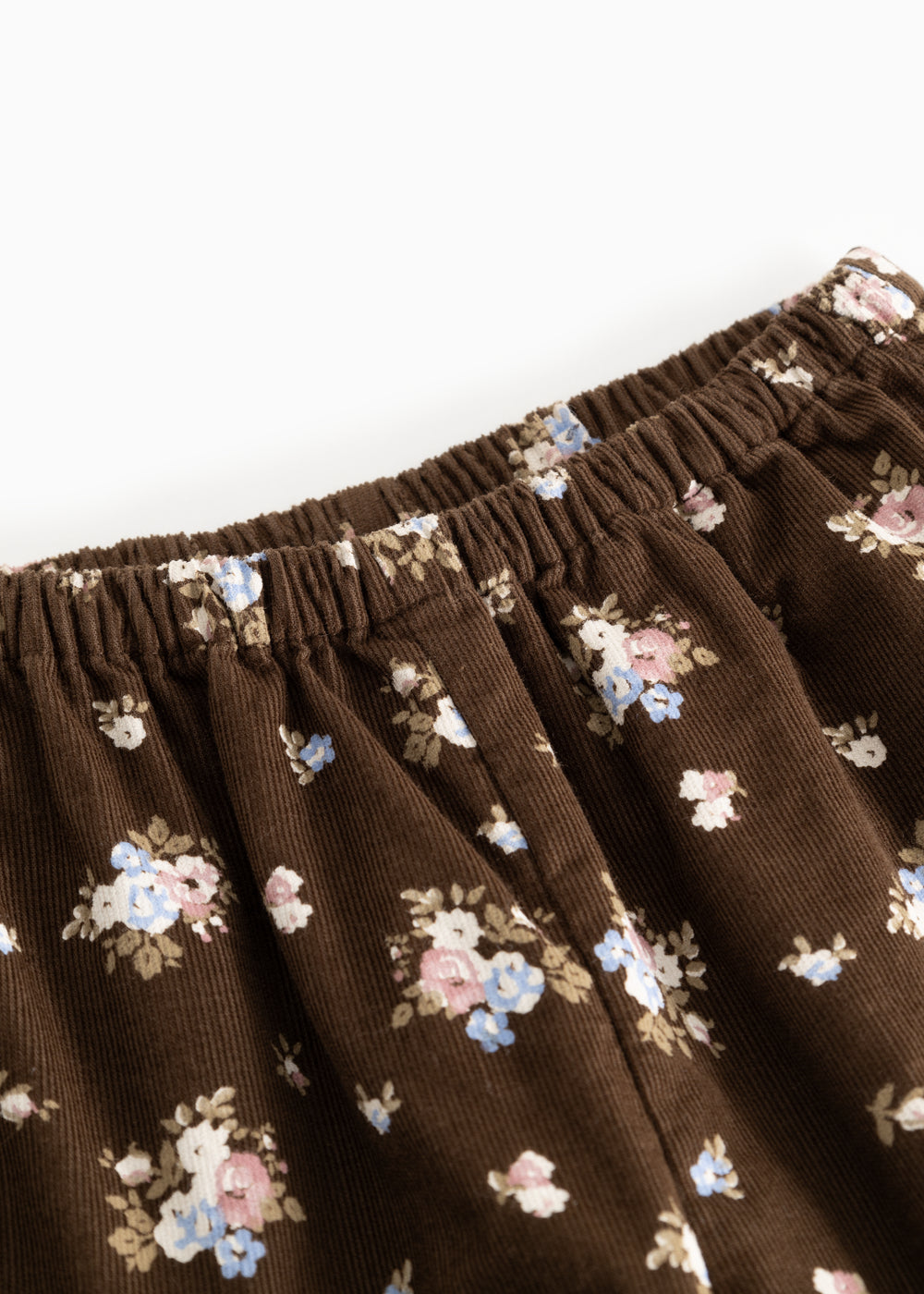 Brune bukser med elastisk linning og små blomsterprint over det hele