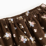 Brune bukser med elastisk linning og små blomsterprint over det hele