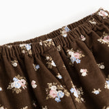 Brune bukser med elastisk linning og små blomsterprint over det hele