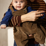 Blå strikket cardigan på baby med sorte ribkanter og knaplukning.