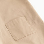 Beige selebukser til baby med forlommelomme og stikninger.