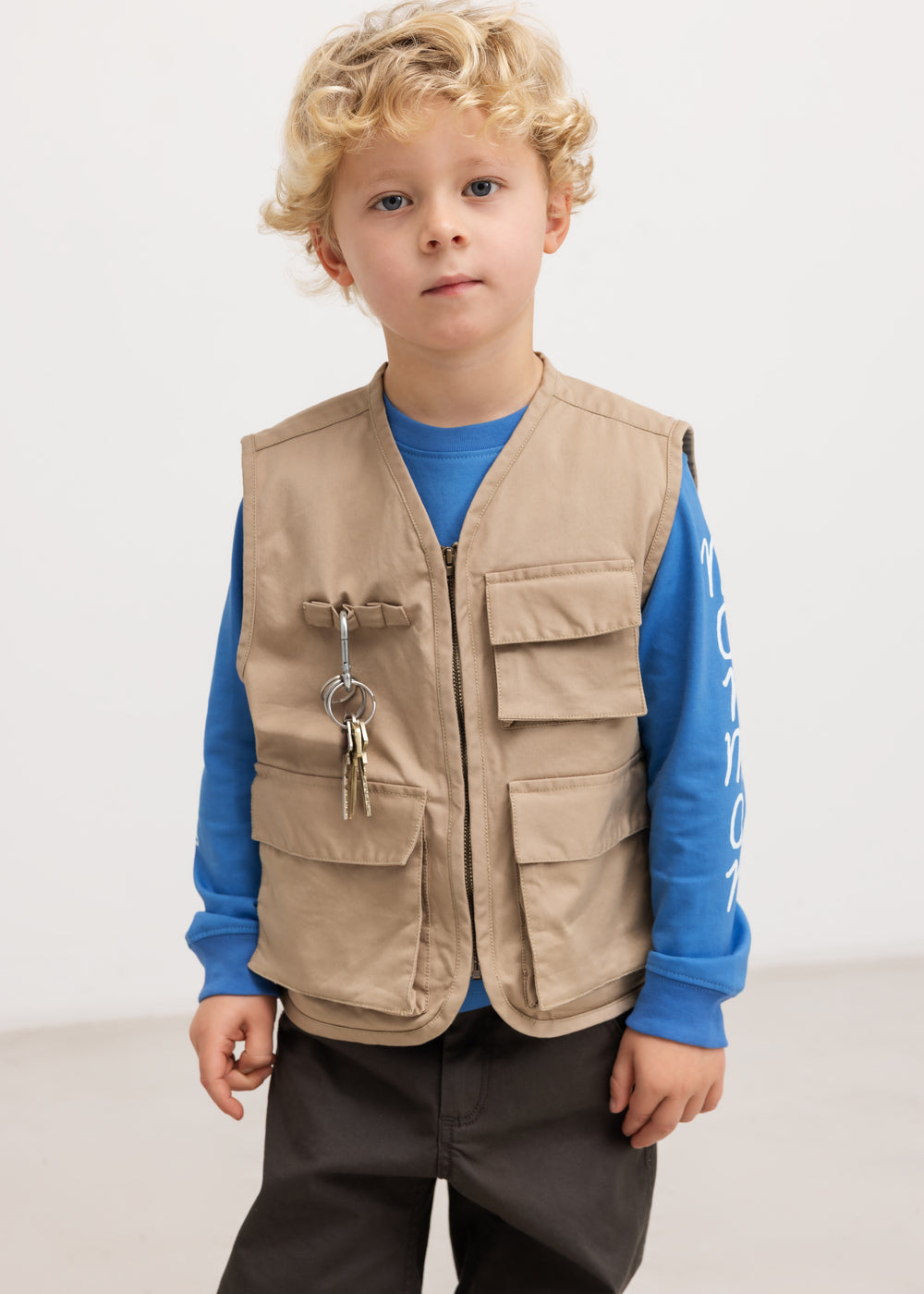Langærmet bluse i blå med Moomin-print, båret under beige scout-vest