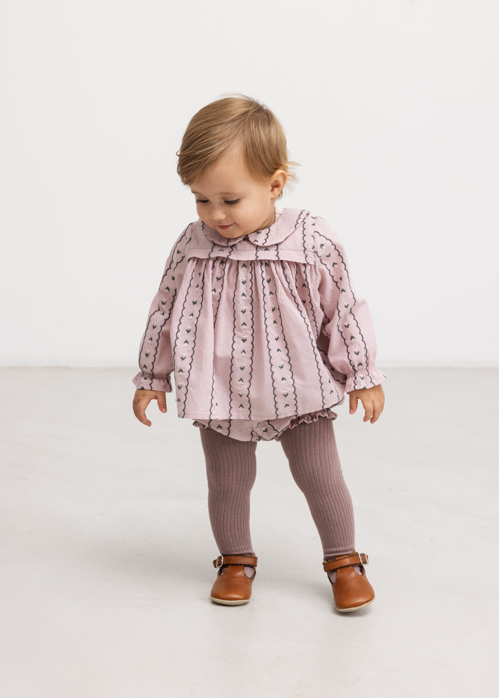 Lyserød babybluse på model med lange ærmer og knaplukning foran