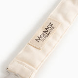 Nærbillede af Mamar Cotton-mærke på beige suttesnor i stof