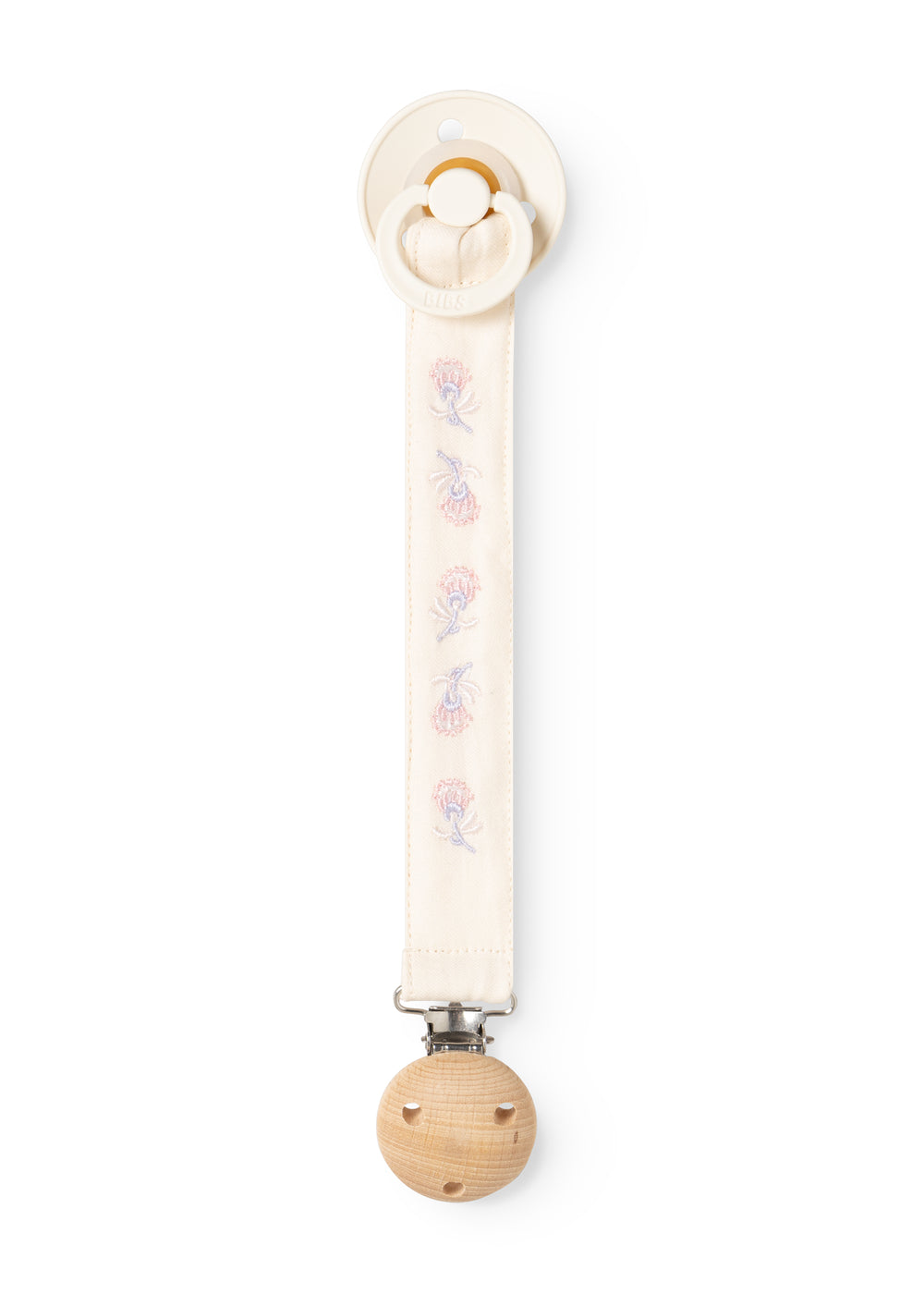 Beige suttesnor med stofbånd, blomsterbroderi, rund træclips og sikkerhedskrog