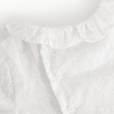 Hvid babybluse med rynket flæsekant ved halsudskæringen