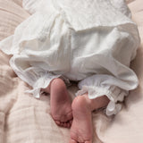 Hvide babybukser på baby med flæsekant ved ankler og elastisk benafslutning