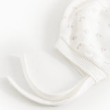 Hvid babyhue med små blomsterprint, ribkant og lange bindesnore