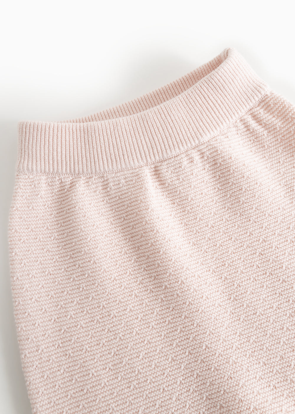 Pira strikbukser i rosa, ribkant ved linning og strikket tekstur, tæt på