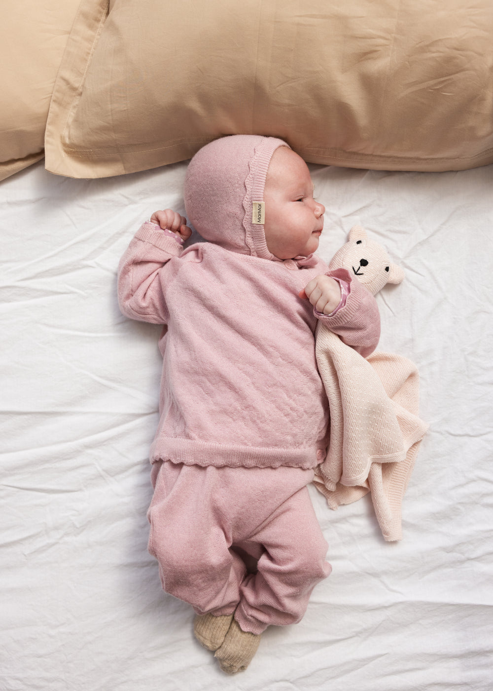 Rosa nusseklud i teddystof med bamsehoved, foldet som blødt tæppe
