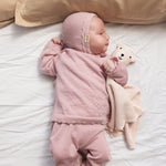 Lyserød strikcardigan på baby med knaplukning og ribkant ved nederkant og ærmer
